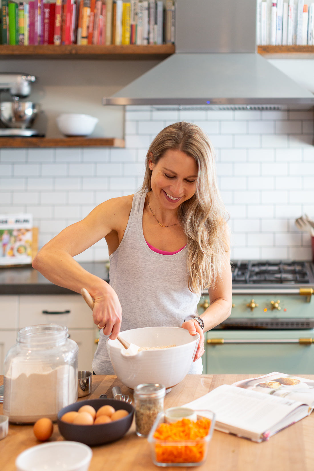 Vertical photo of Run Fast Eat Slow Superhero Muffins Founder Elyse Kopecky mixing muffins in her kitchen