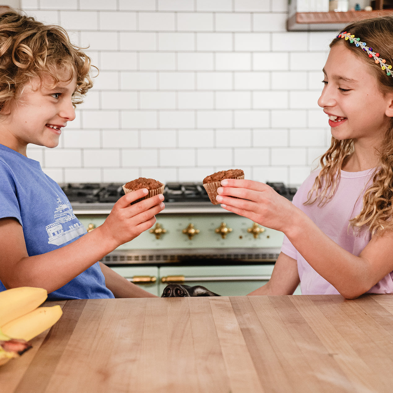 Two kids in a kitchen sharing Superhero Muffins.