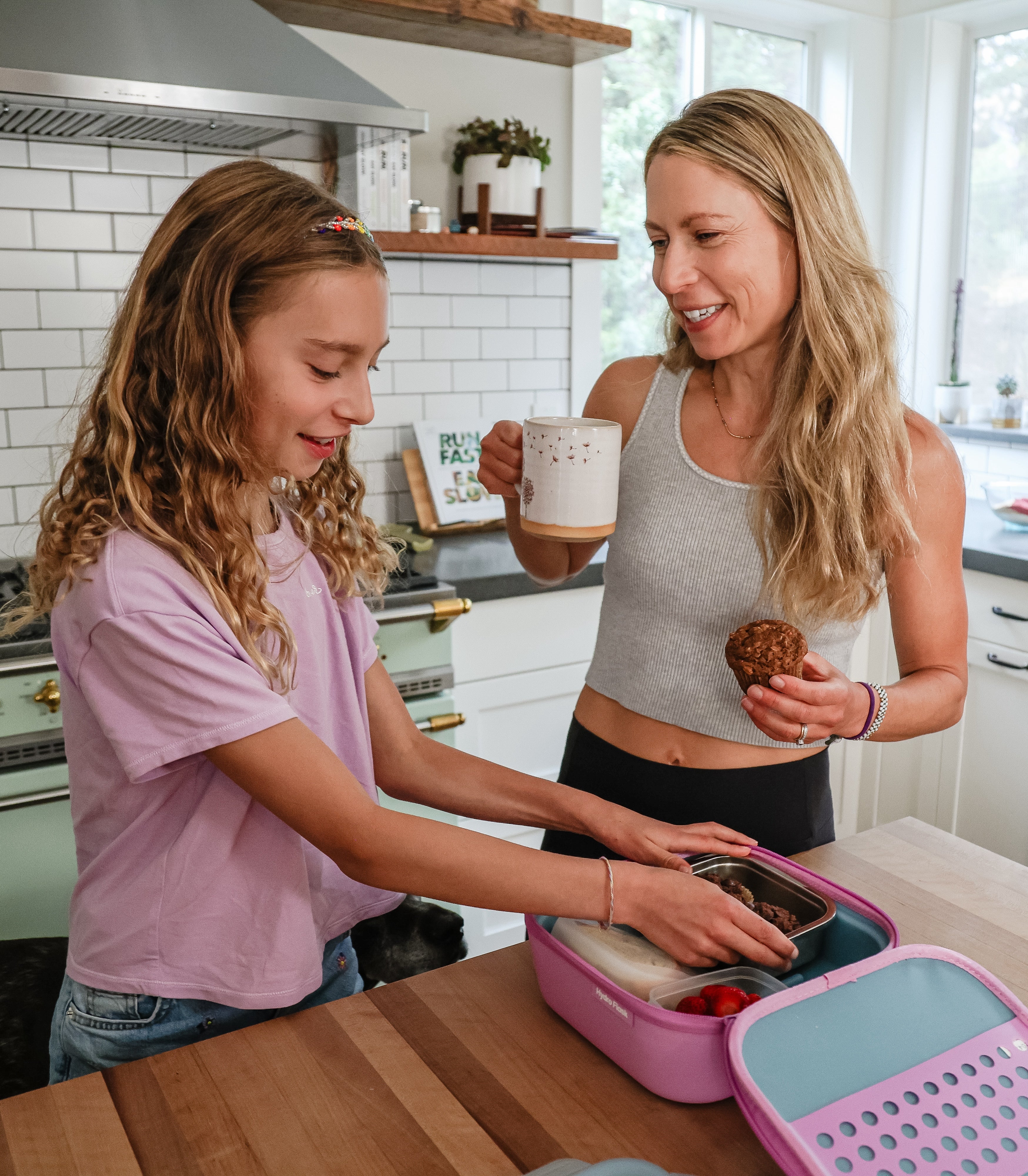 Superhero Muffins founder Elyse Kopecky with her daughter in kitchen packing lunch and drinking coffee with Superhero Muffins