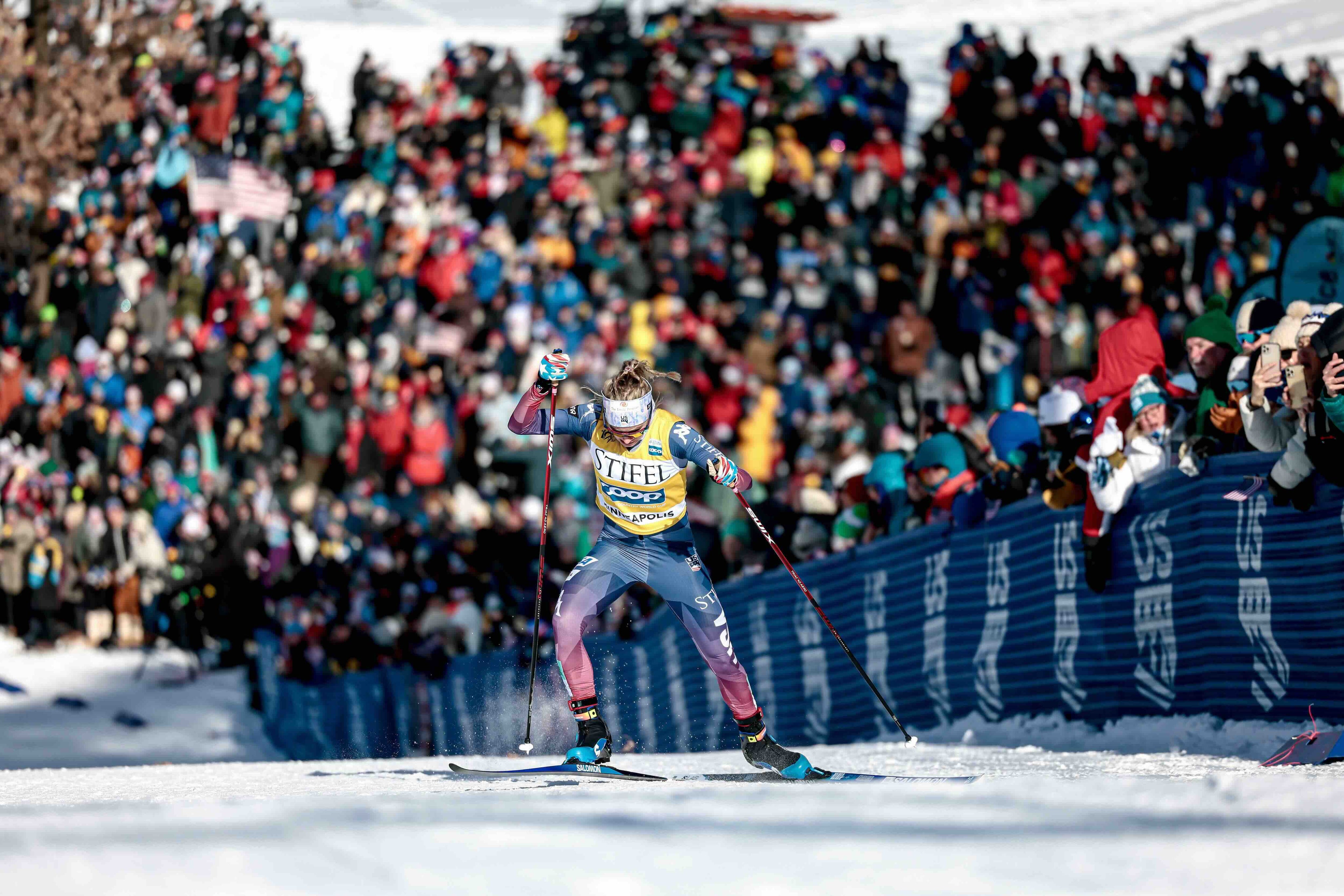 Superhero Muffins customer Jessie Diggins competing in skiing in front of a crowd of people