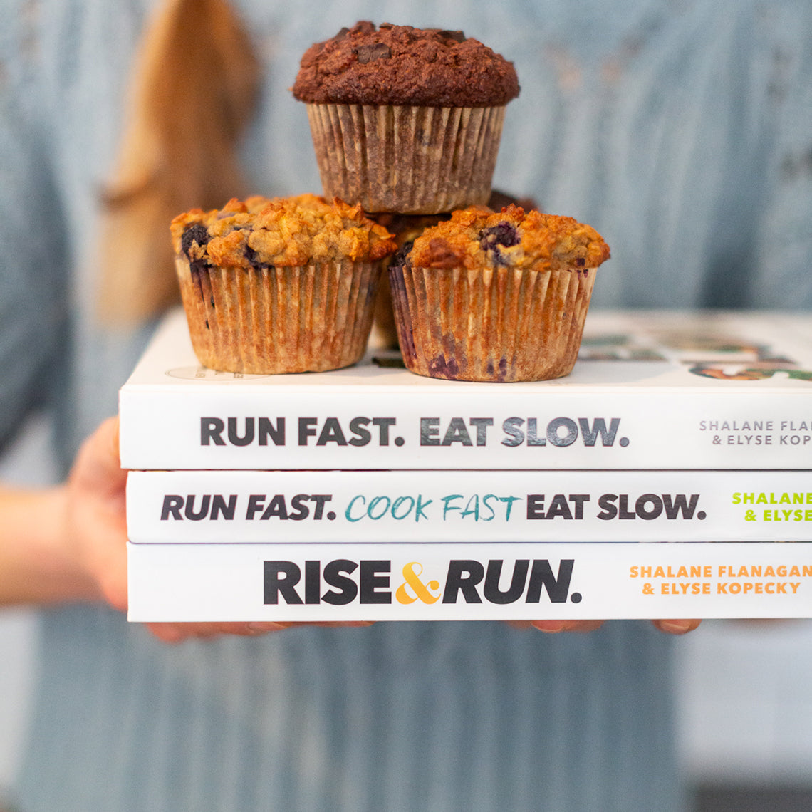 Superhero Muffins on top of a stack of three bestselling books by Run Fast. Eat Slow.